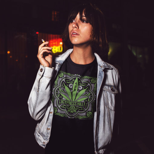 Femme portant un t-shirt Cypress Hill noir avec un motif représentant une feuille de cannabis